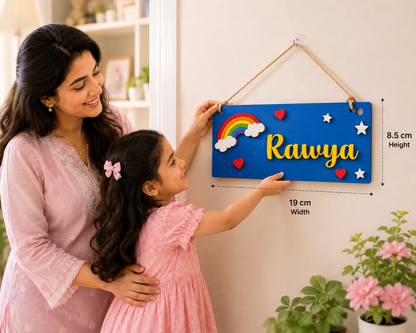Woman and child holding a colorful nameplate with 'Rawya' on a light background