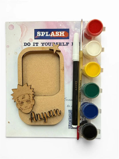 Custom laser-cut wooden photo frame kit with a Naruto character design and the name 'Anyan', shown with a paint palette, paint pots, a paintbrush, and a marker on a white background.