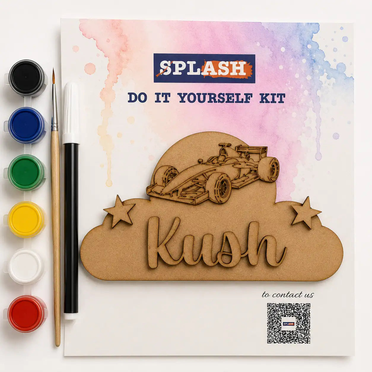 A personalized wooden laser-cut kit for kids, featuring a custom name 'Kush' in a cloud shape with a race car illustration. The kit is displayed on its printed backing card, accompanied by paint colors, a paintbrush, and a paint stick on a clean white background.