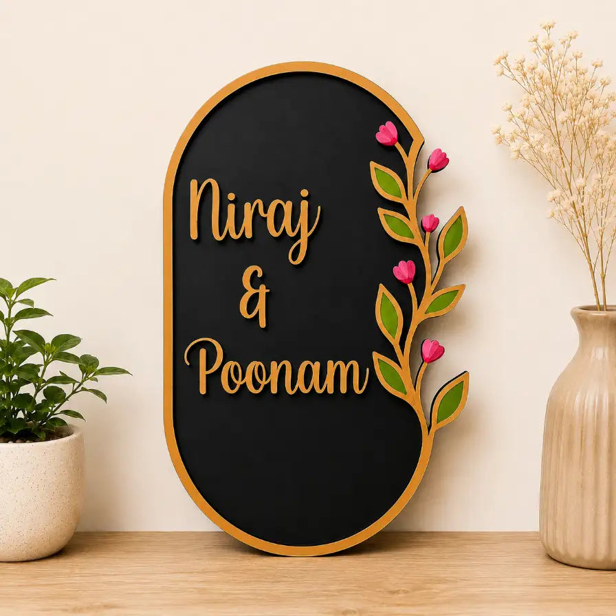 Decorative wall art with 'Niraj & Poonam' text on a black background with wooden frame and floral design.