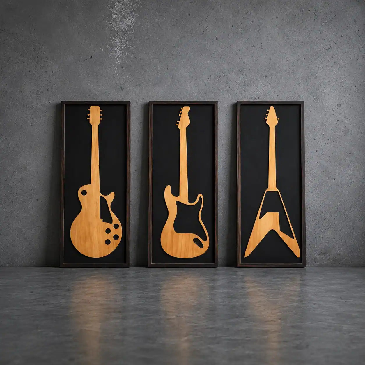 Three framed wooden guitar models on a gray wall.