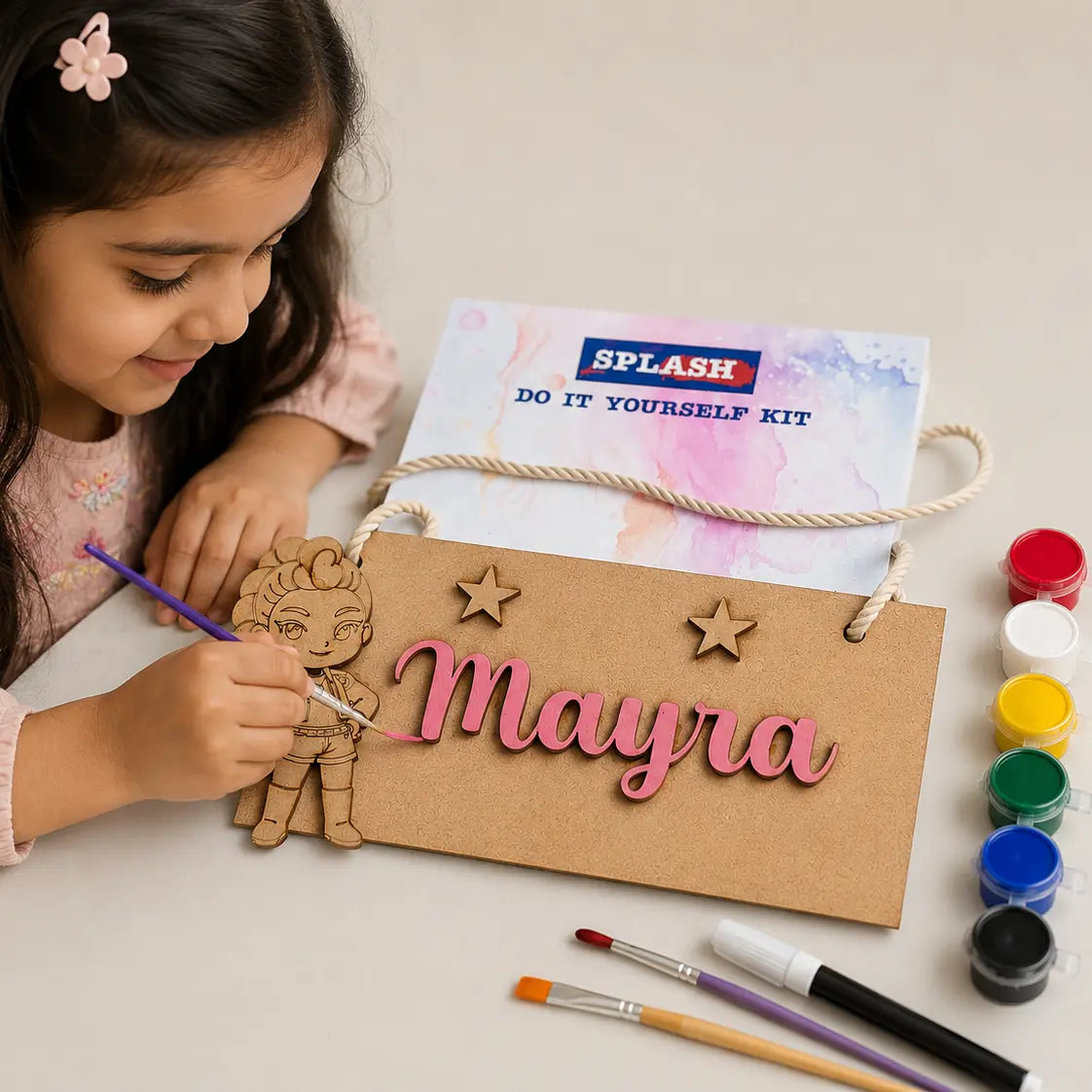 Child painting a personalized name sign with 'SPLASH' branding