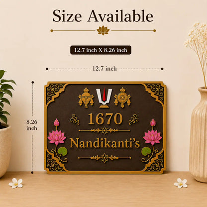 A decorative wall plaque shown in a styled interior setting with size callouts above it. The plaque is dark brown with ornate gold detailing, pink lotus flowers, green leaves, and the text '1670 Nandikanti's'.