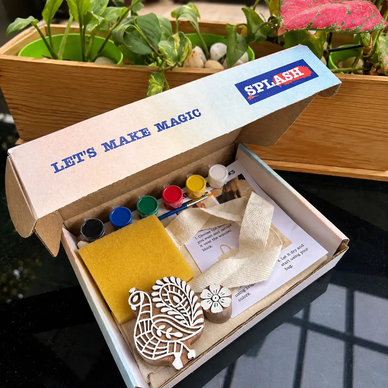 Open craft kit with supplies including markers, a sponge, and a wooden peacock stamp, branded 'Splash'.