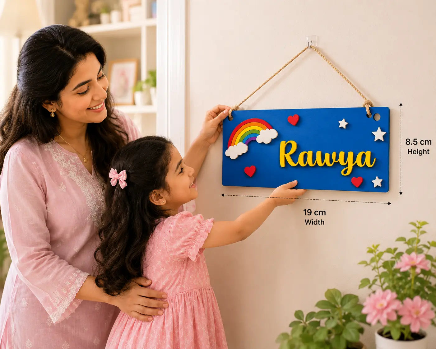 Woman and child holding a colorful nameplate with 'Rawya' on a light background