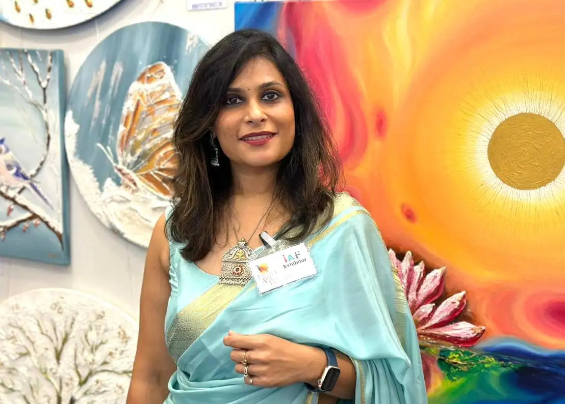 A woman wearing a light blue and gold saree with intricate embroidery.